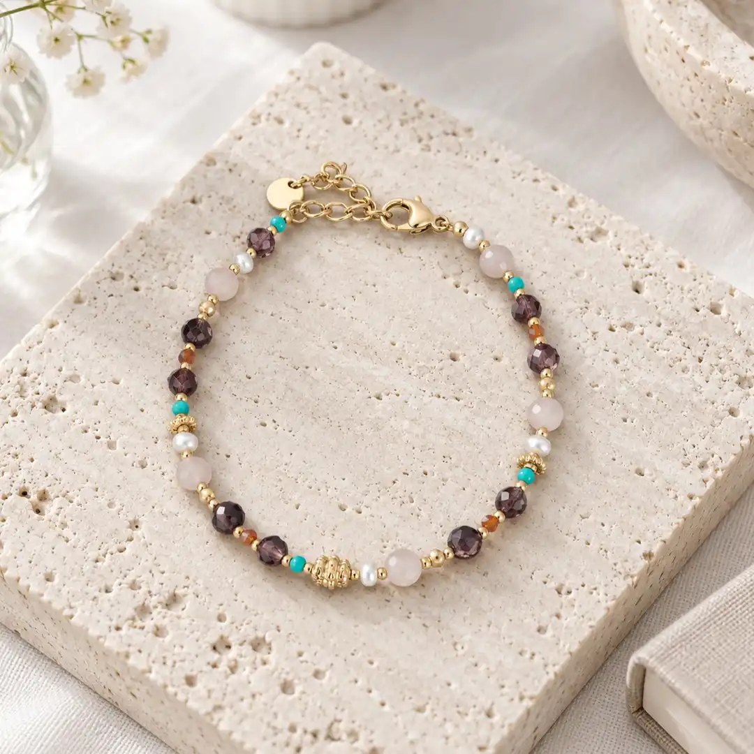 Bracelet petites pierres multicolores et perles dorées en acier inoxydable, avec fermoir mousqueton et chaînette d'extension.
