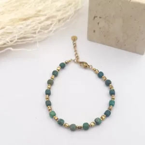 Bracelet femme à petites pierres vertes cubiques et intercalaires dorés, avec fermoir mousqueton et chaînette d'extension.