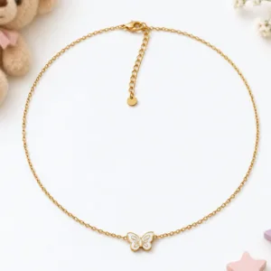 Collier acier enfant doré avec papillon blanc, chaîne fine et chaînette de réglage.